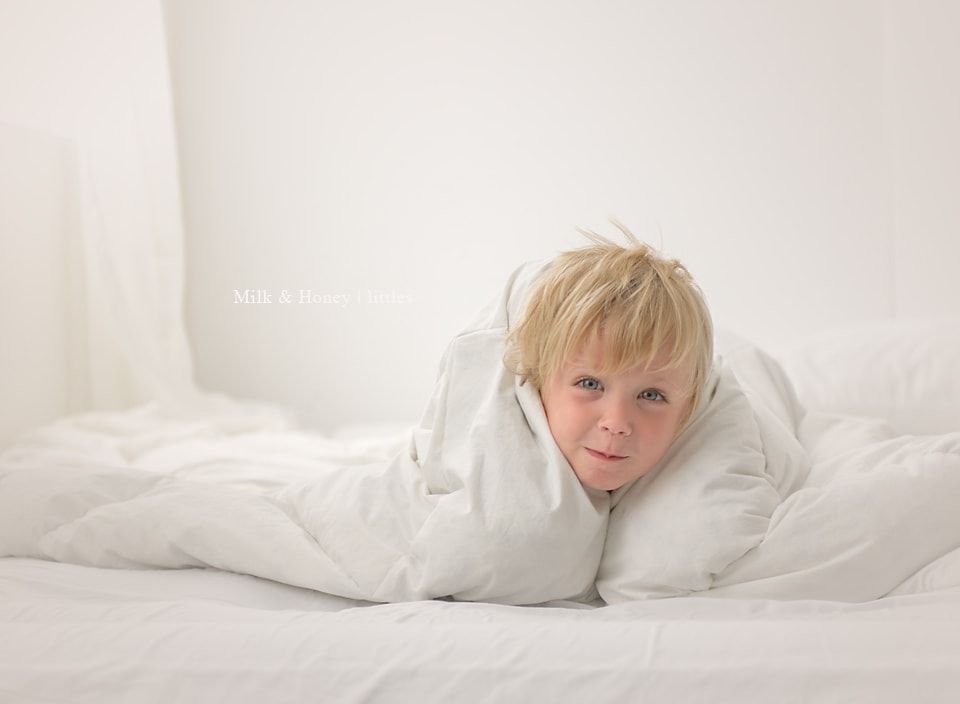 boy on bed next to window