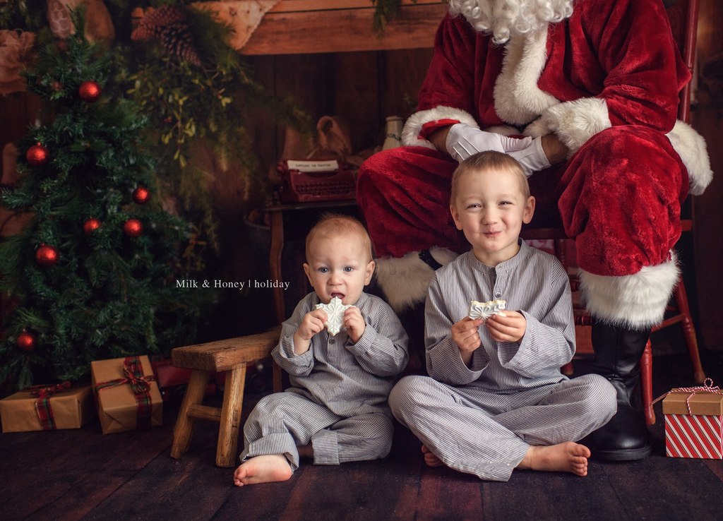 two boys eating cookies with santa