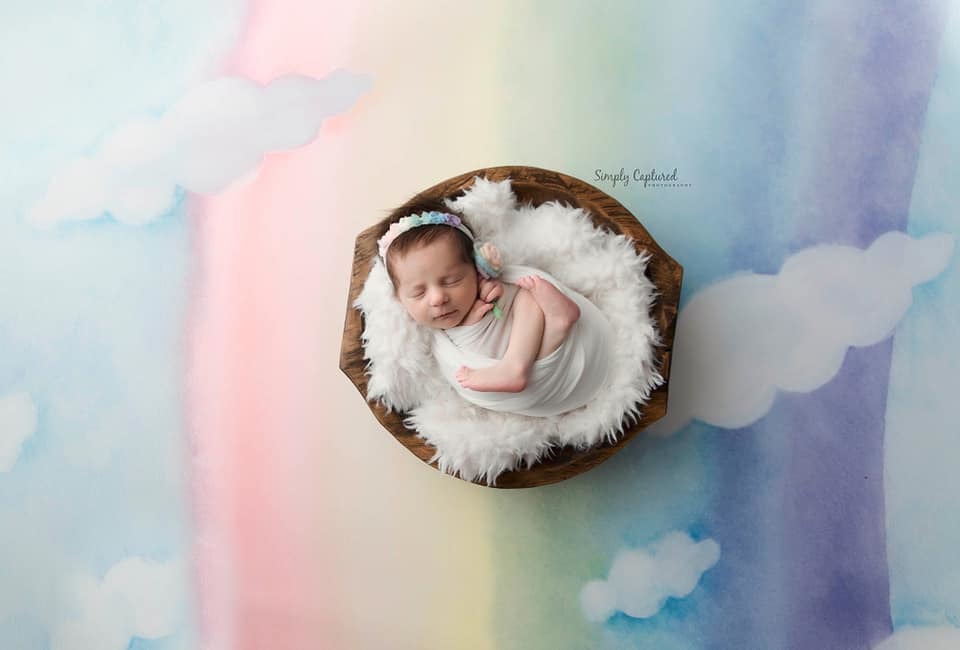baby in bowl on a rainbow background