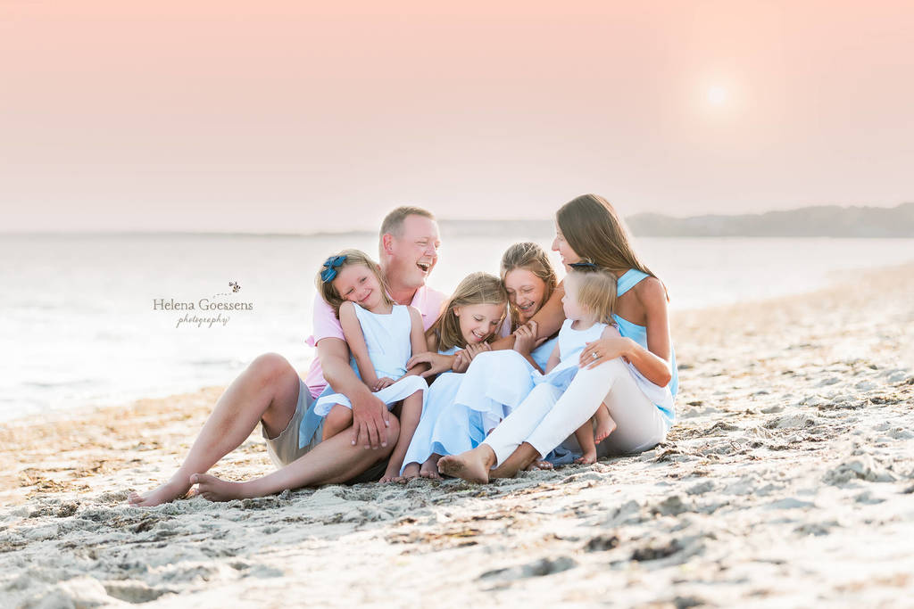 family posing on beach for photo