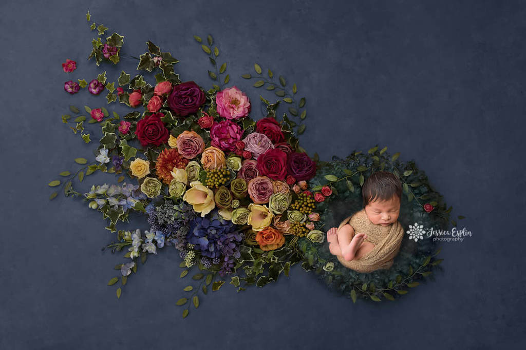 newborn in a a ring of coloured flowers
