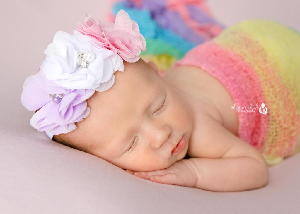newborn wrapped in rainbow coloured wraps