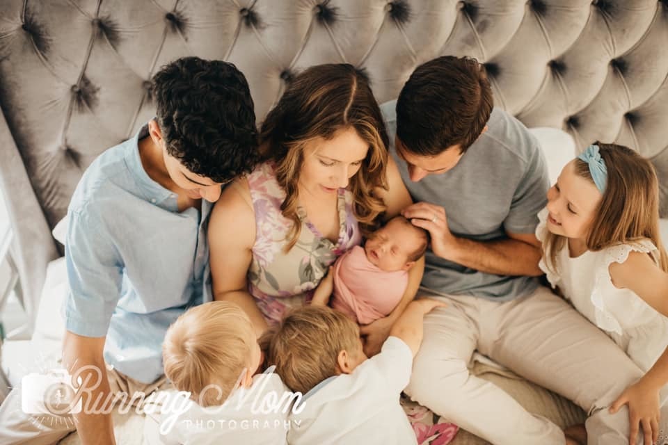 overhead shot of family with newborn on bed