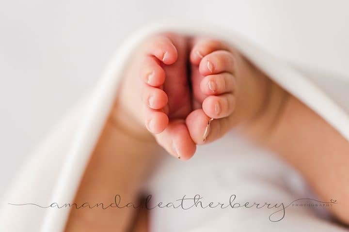 macro newborn photography of feet
