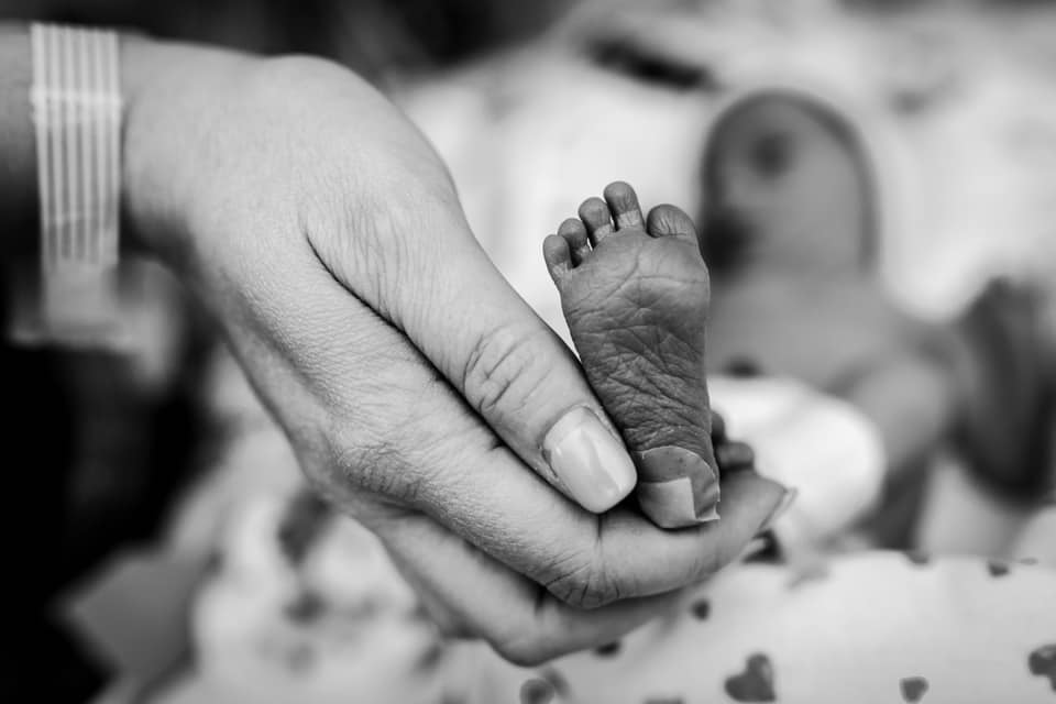 hand holding tiny newborn foot