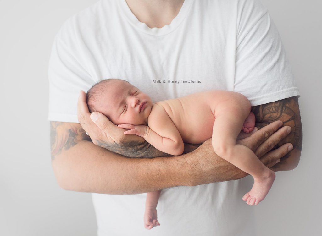 dad holding newborn on arms