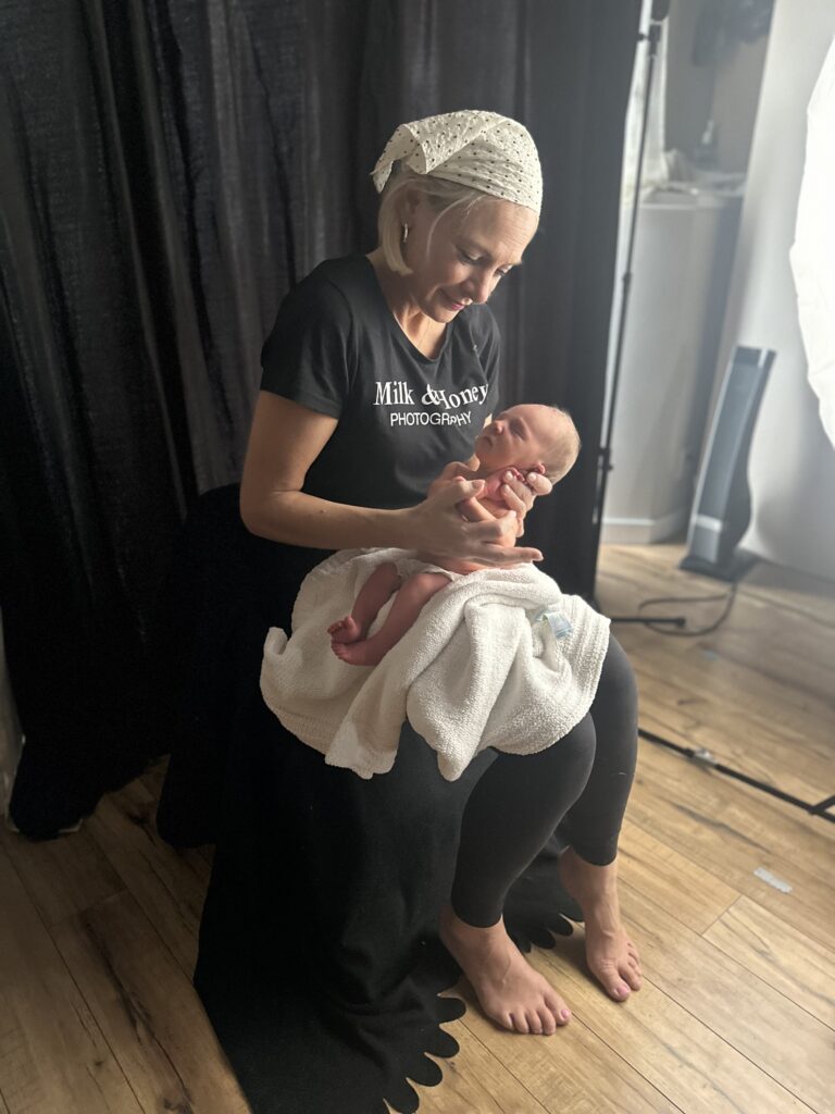 newborn photographer demonstrating safe baby handling