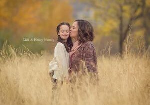 mom kissing daughter