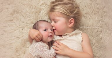 safe newborn sessions with siblings on the floor